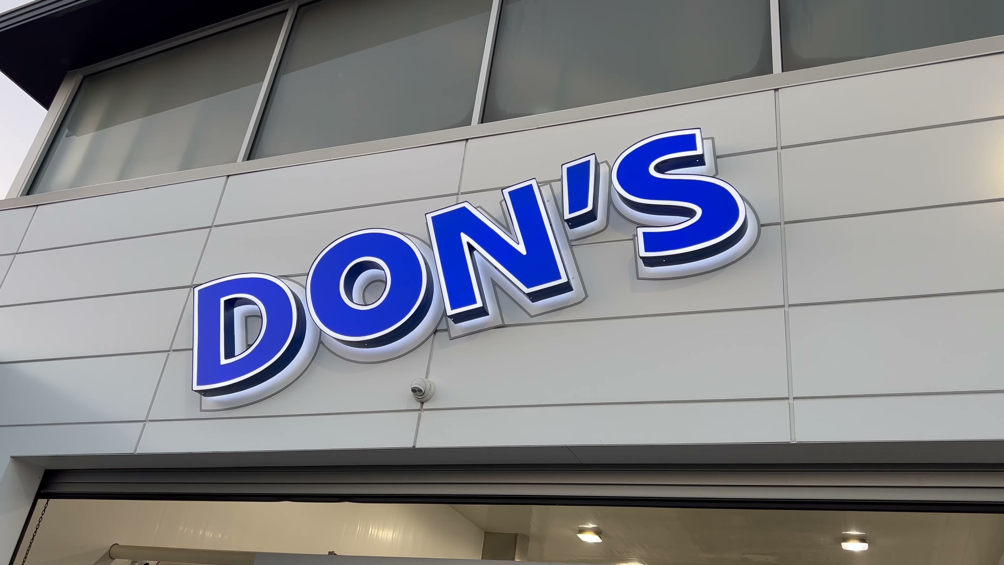The lit DON'S sign over the wash tunnel exit